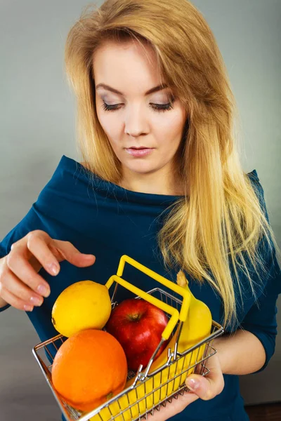 Mujer sosteniendo cesta con frutas en el interior — Foto de Stock
