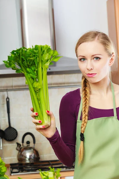 Kadın mutfakta yeşil kereviz tutar — Stok fotoğraf