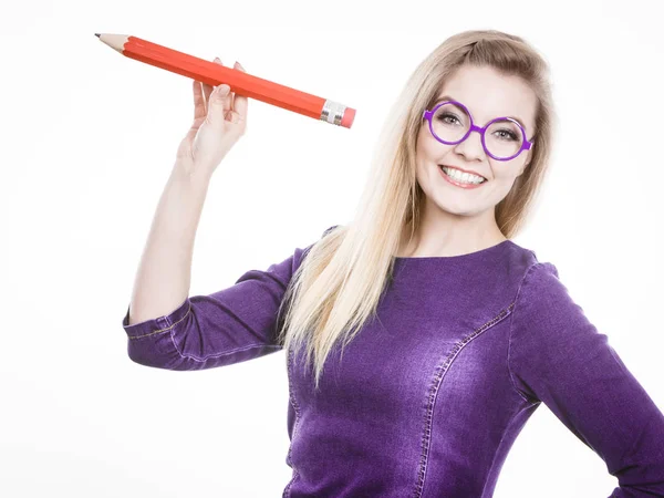 Mujer sonriente sostiene un lápiz grande en la mano — Foto de Stock