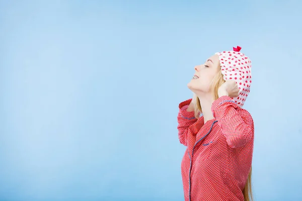 Giovane donna che indossa pigiama rosa mettere cuffia da bagno — Foto Stock