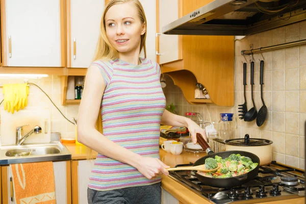 Kobieta gotowanie wymieszać smażyć mrożone warzywa na patelni — Zdjęcie stockowe