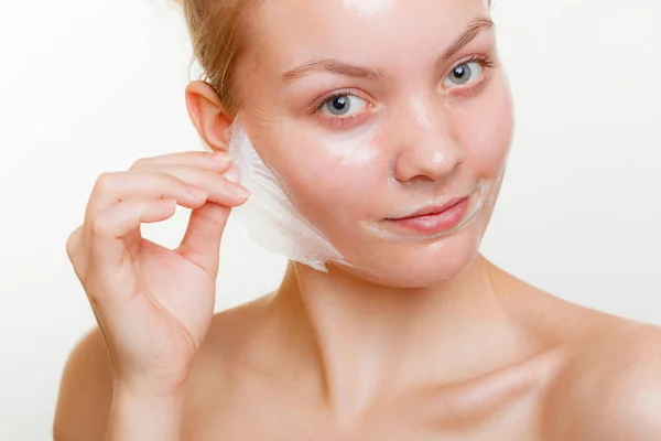 Frau entfernt Gesichtspeeling von Maske. — Stockfoto