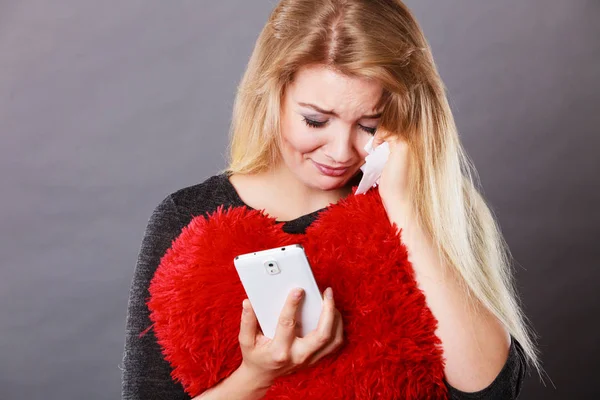 Traurige, herzzerreißende Frau blickt auf ihr Handy — Stockfoto