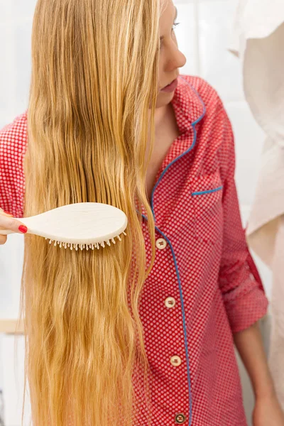 Žena kartáčování dlouhé vlasy v koupelně — Stock fotografie