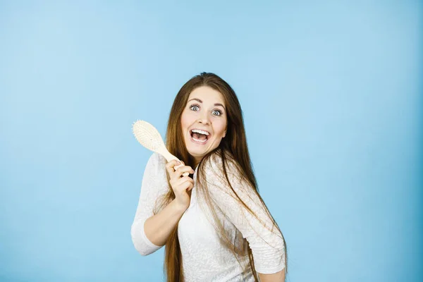 Щаслива жінка чистить волосся — стокове фото