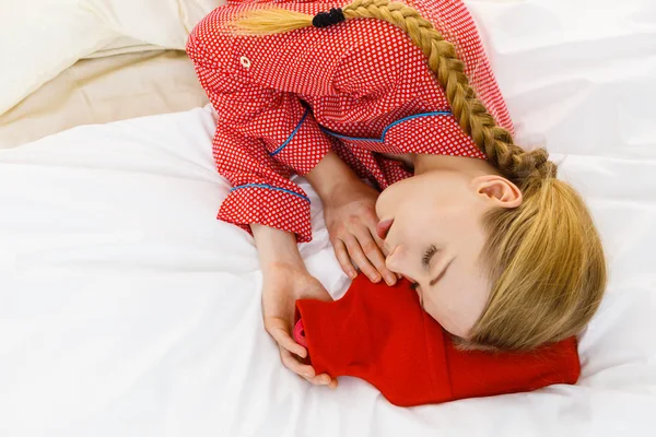Donna che dorme con bottiglia d'acqua calda rossa calda — Foto Stock
