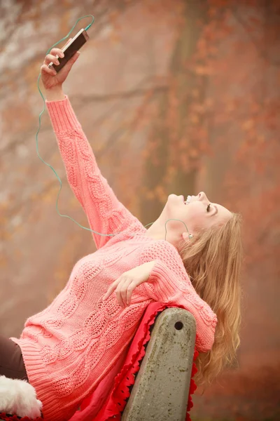 Ragazza ascoltare musica nel parco autunnale — Foto Stock