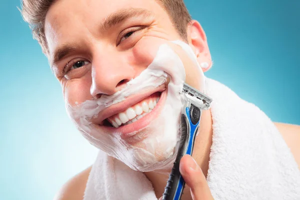 Feliz hombre afeitándose con afeitadora con espuma crema . — Foto de Stock