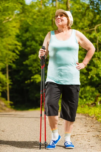 Seniorin übt Nordic Walking im Park — Stockfoto