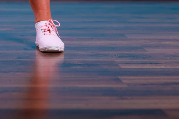 Vrouwelijke voeten dragen van schoenen sneakers. — Stockfoto