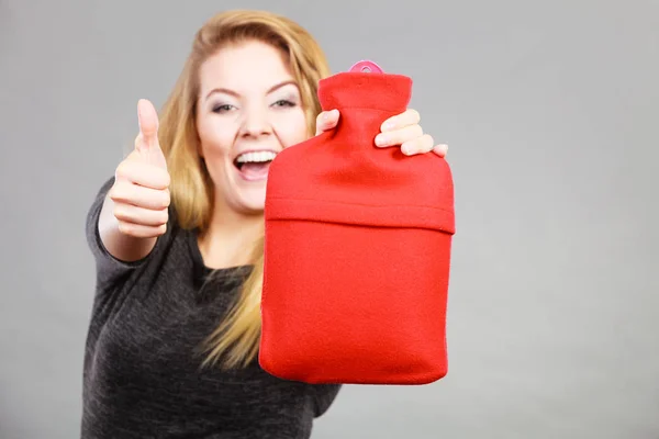 Happy woman holds hot water bottle — Stock Photo, Image