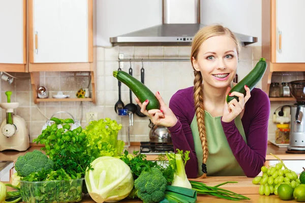 Femme au foyer dans la cuisine avec des légumes verts — Photo