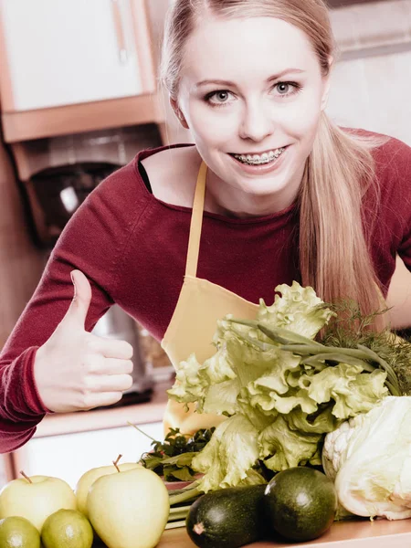 Mulher na cozinha com muitos vegetais verdes — Fotografia de Stock