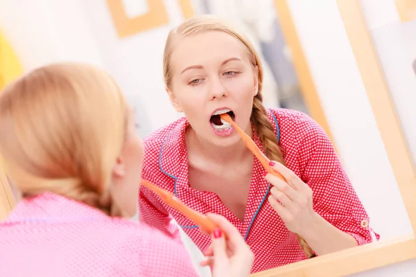 Mulher escovando os dentes de limpeza no banheiro — Fotografia de Stock