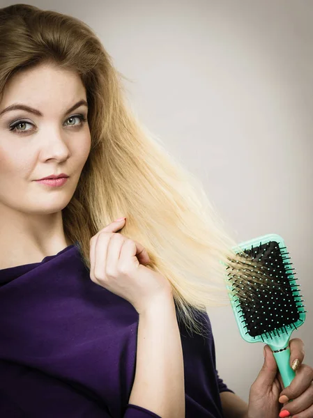 Femme brossant ses cheveux longs avec une brosse — Photo