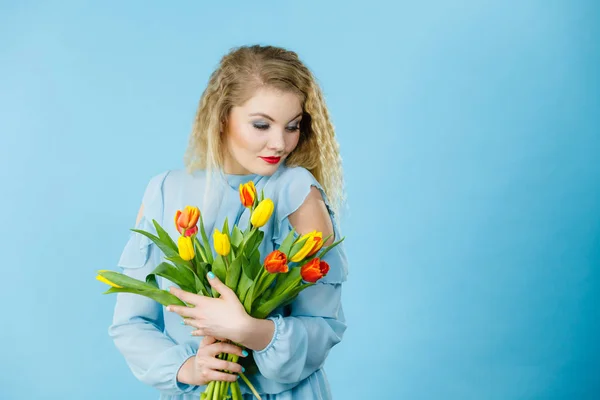 Pretty woman s bandou červené žluté tulipány — Stock fotografie