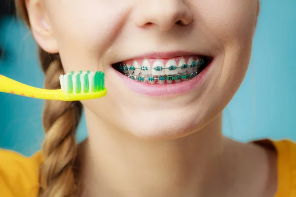 Mulher com aparelho de dentes usando escova — Fotografia de Stock