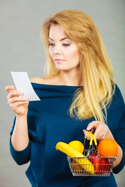 Femme inquiète tenant panier avec des fruits — Photo