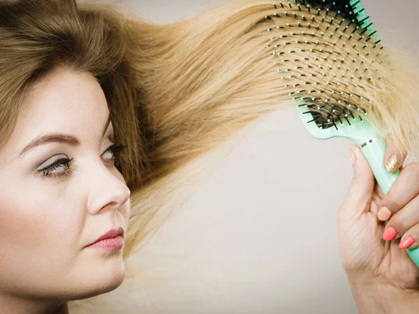 Žena kartáčování dlouhé vlasy s kartáčem — Stock fotografie