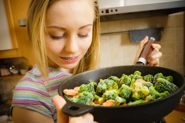 Žena vaření míchejte smažit Zmrazená zelenina na pánvi — Stock fotografie