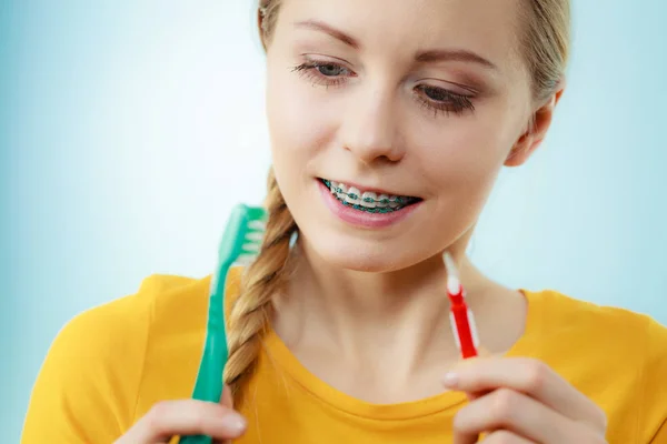 Menina com aparelho de dentes usando escova interdental e tradicional — Fotografia de Stock