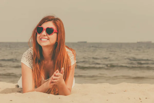 Roodharige volwassen vrouw liggend op het strand — Stockfoto