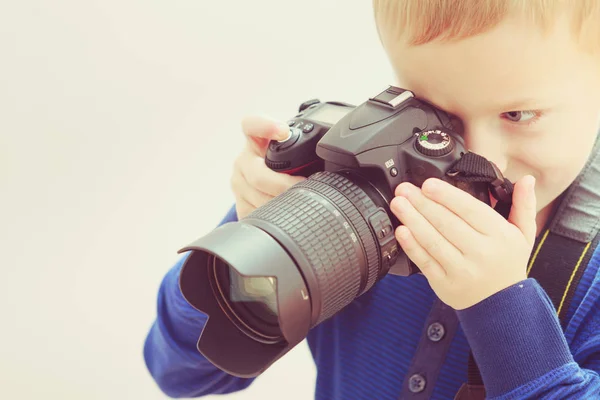 Kid playing with big professional digital camera — Stock Photo, Image