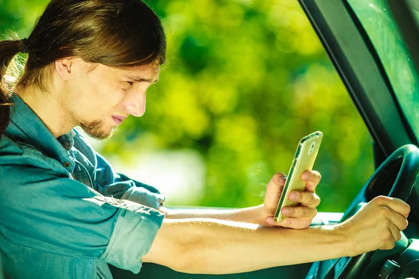 Mannen som använder sin telefon när han kör bil. — Stockfoto