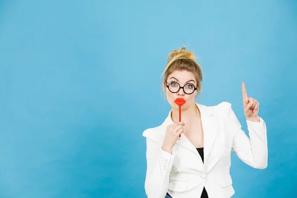 Kvinna håller falska läppar på pinne pekar på kopia utrymme — Stockfoto