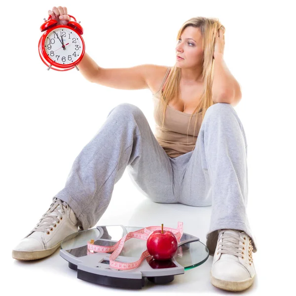 Mujer sosteniendo manzana, cinta métrica y reloj — Foto de Stock