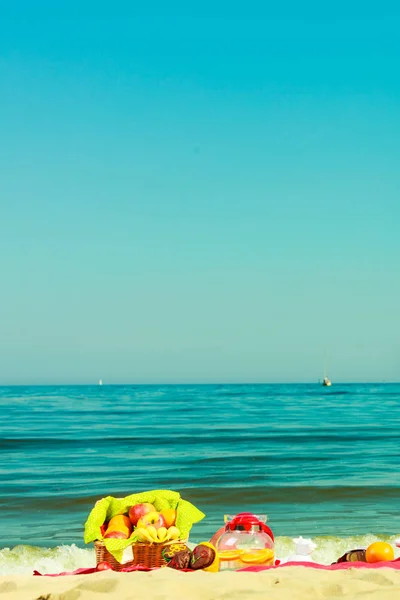 Panier de pique-nique sur couverture près de la mer — Photo