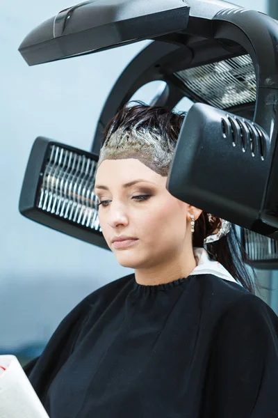 Donna in parrucchiere, asciugatura capelli sotto macchina — Foto Stock