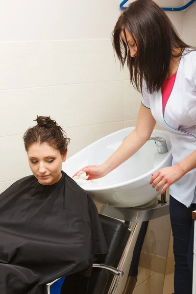 Kadeřník, mýt vlasy zákazníků žena — Stock fotografie