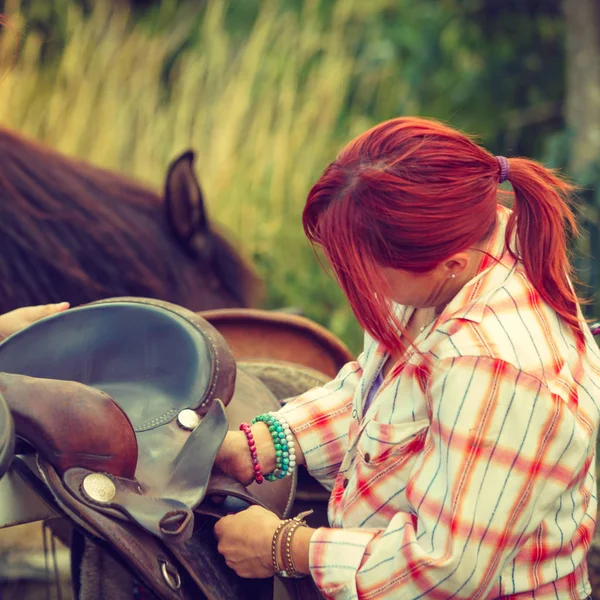 Cowgirl, przygotowania konia do jazdy na wsi — Zdjęcie stockowe