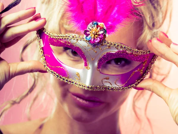 Žena středního věku drží karnevalové masky. — Stock fotografie