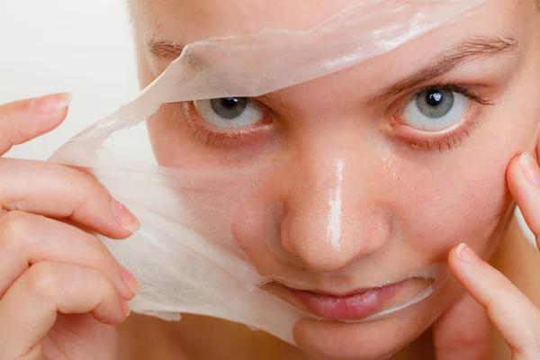 Kvinna att ta bort facial peel off mask närbild — Stockfoto