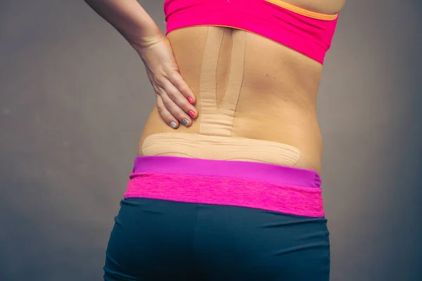 Mujer con kinesio médico grabando en la espalda — Foto de Stock