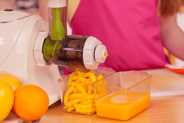 Mujer haciendo jugo de naranja en la máquina de juicer — Foto de Stock