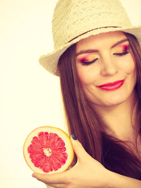 Vrouw met de helft van de grapefruit citrusvruchten in de hand — Stockfoto