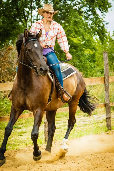 Cowgirl doen paard rijden op platteland weide — Stockfoto