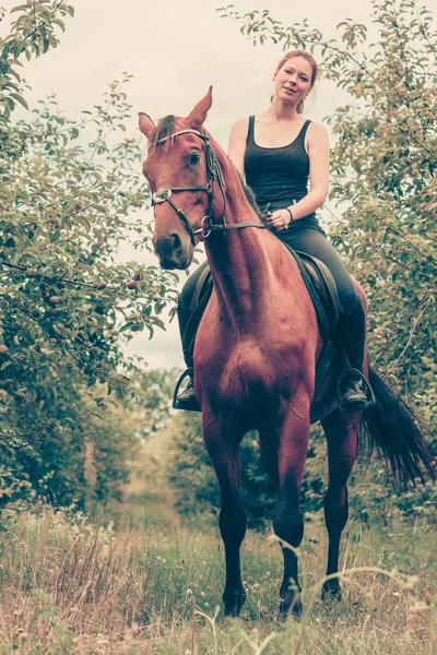 Mladá žena sedící na koni — Stock fotografie
