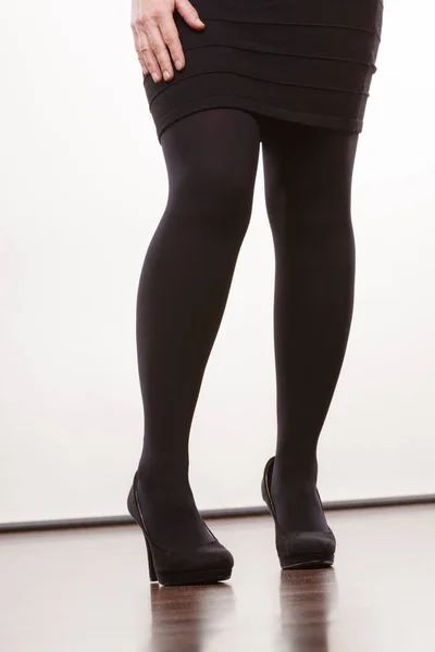 Kvinnliga ben i svart strumpbyxor krängt skor — Stockfoto