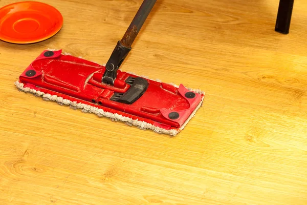 Red mop cleaning wooden floor — Stock Photo, Image