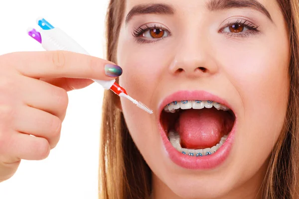 Mujer sonriendo limpiando dientes con aparatos ortopédicos —  Fotos de Stock
