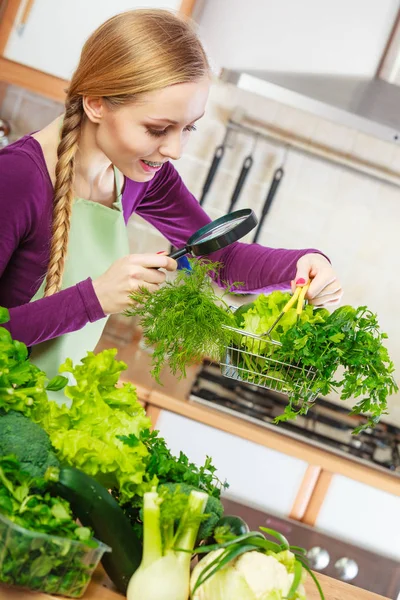 Žena při pohledu přes lupu na koš zeleniny — Stock fotografie