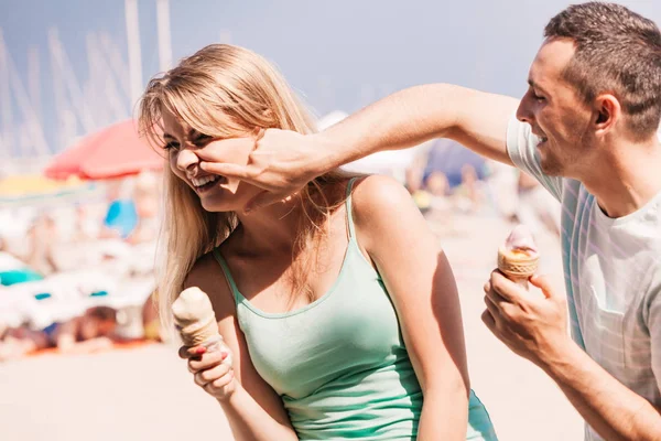Mężczyzna i kobieta jedzący lody na plaży — Zdjęcie stockowe