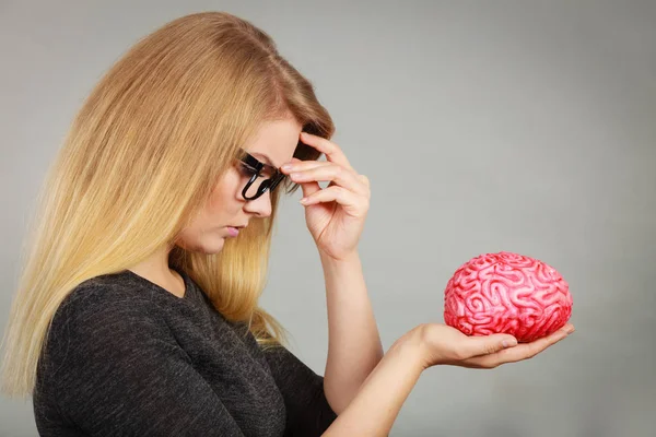 Žena myslí a drží falešné mozku — Stock fotografie