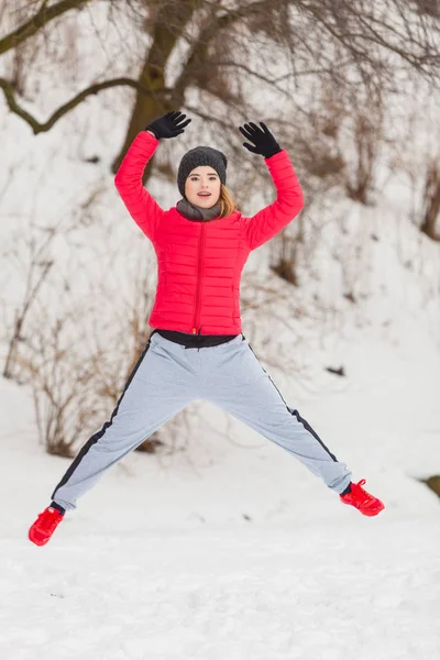 Mulher vestindo sportswear exercitando fora durante o inverno — Fotografia de Stock