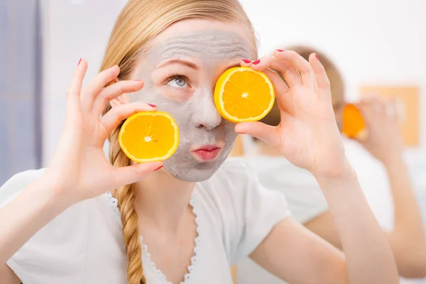 Jovem feliz tendo máscara facial segurando kiwi — Fotografia de Stock