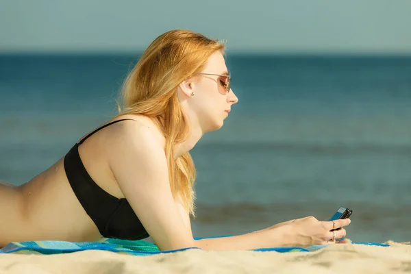 Mujer en bikini tomando el sol y relajándose en la playa —  Fotos de Stock